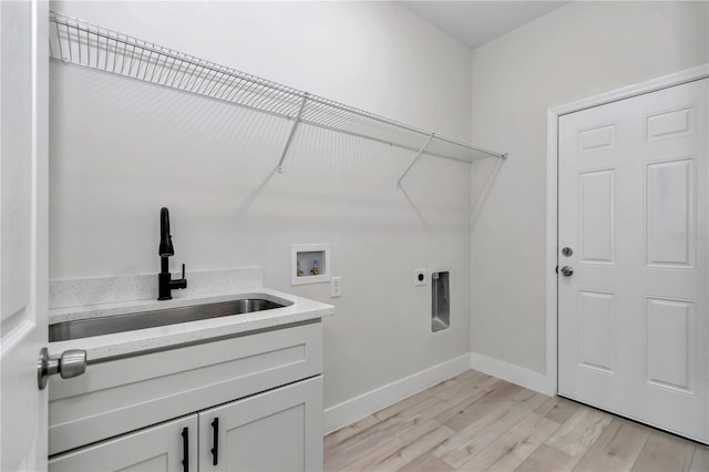 laundry room featuring electric dryer hookup, a sink, light wood finished floors, baseboards, and hookup for a washing machine