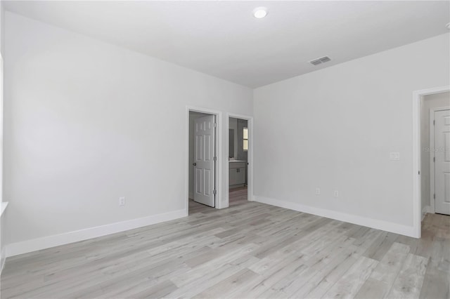 unfurnished room featuring visible vents, baseboards, and light wood finished floors