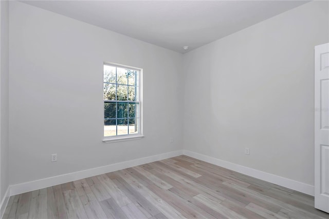 empty room featuring baseboards and light wood finished floors