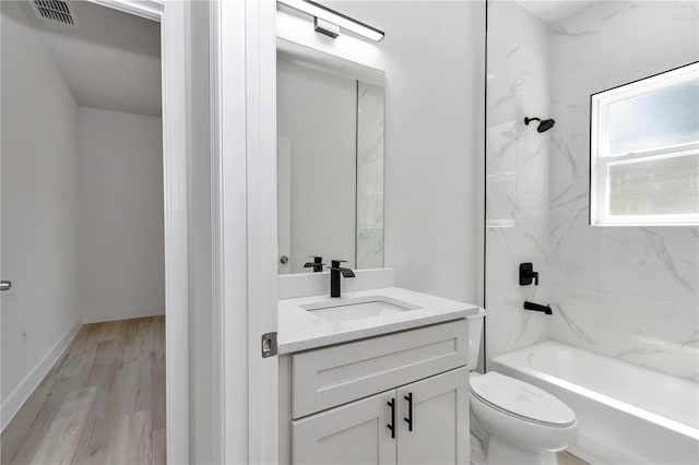 full bath with visible vents, toilet, bathing tub / shower combination, wood finished floors, and vanity