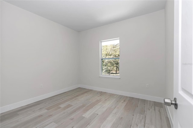 unfurnished room with light wood-style flooring and baseboards