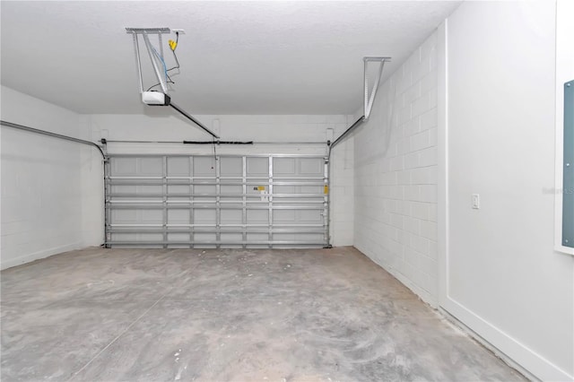 garage featuring a garage door opener and concrete block wall