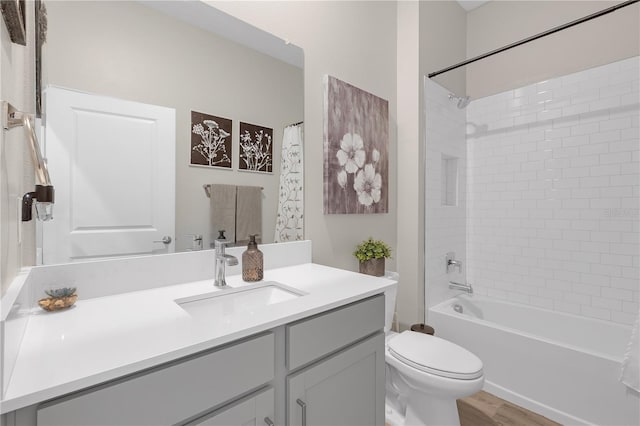 bathroom featuring vanity, shower / tub combination, toilet, and wood finished floors