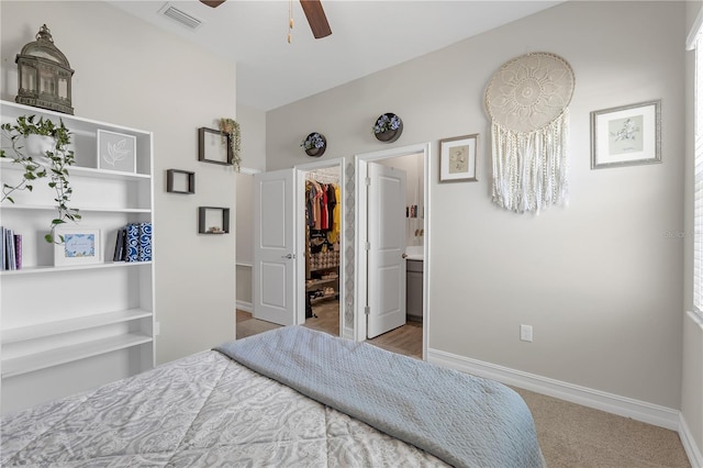 bedroom with baseboards, visible vents, ensuite bath, a spacious closet, and a closet