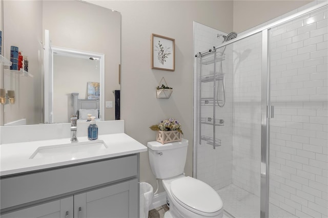 bathroom with toilet, a stall shower, and vanity