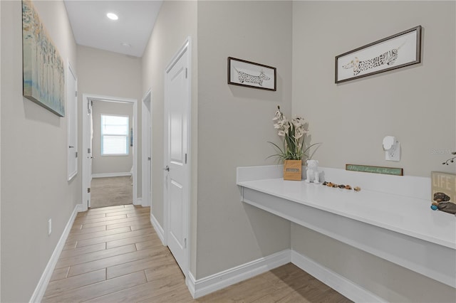 hallway featuring recessed lighting, wood finished floors, and baseboards