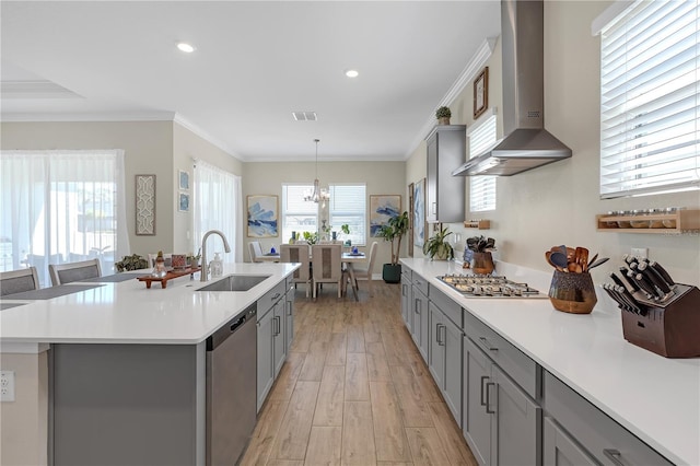 kitchen featuring visible vents, gray cabinets, a sink, appliances with stainless steel finishes, and wall chimney exhaust hood