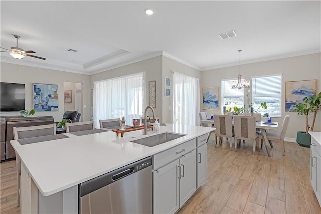 kitchen featuring light wood finished floors, plenty of natural light, a sink, stainless steel dishwasher, and crown molding