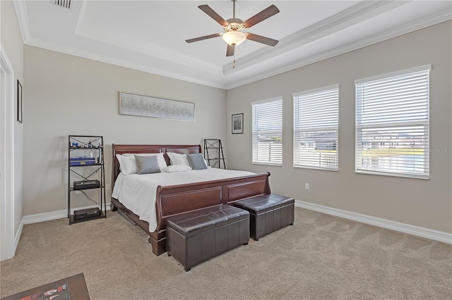 bedroom with a raised ceiling, light colored carpet, baseboards, and ornamental molding