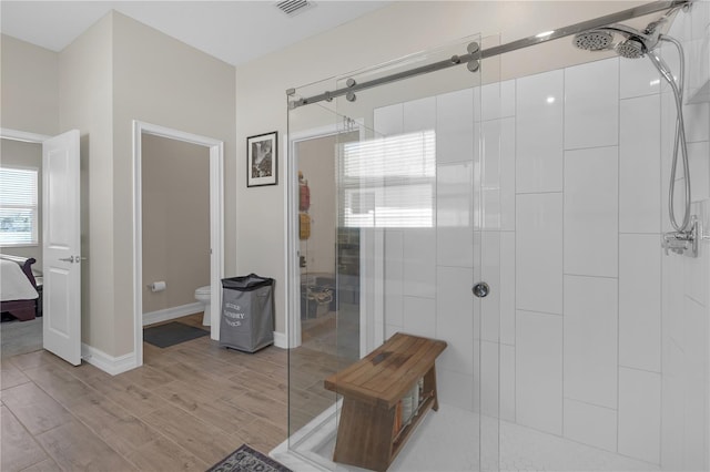 bathroom with wood finished floors, visible vents, a shower stall, ensuite bathroom, and toilet