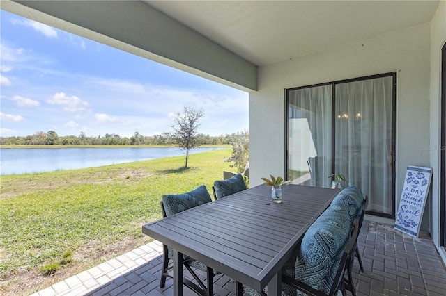 view of patio / terrace with outdoor dining area and a water view