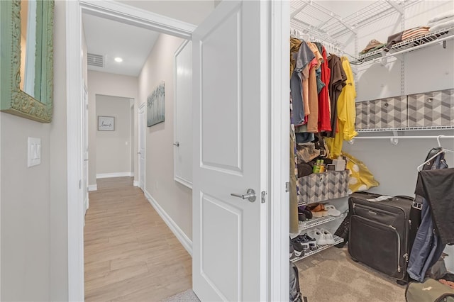 spacious closet with light wood-style floors and visible vents