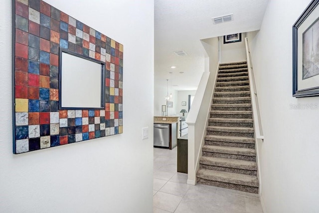 stairway with tile patterned floors and visible vents