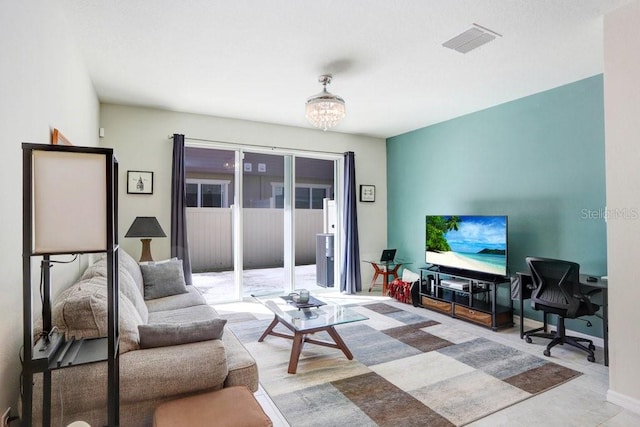 living room featuring visible vents, baseboards, and a notable chandelier