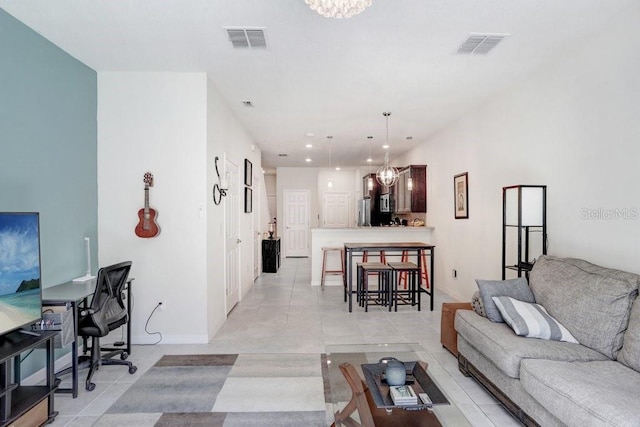 living room featuring visible vents, a chandelier, and light tile patterned flooring