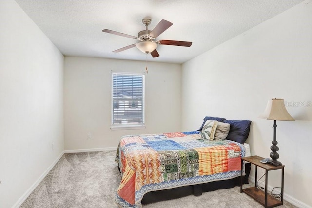 bedroom with a textured ceiling, baseboards, carpet, and a ceiling fan