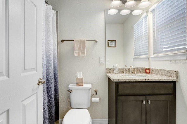 full bathroom with vanity, toilet, and baseboards