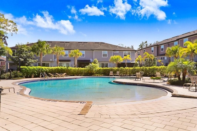 community pool with a patio and a residential view