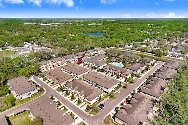 drone / aerial view with a forest view, a water view, and a residential view