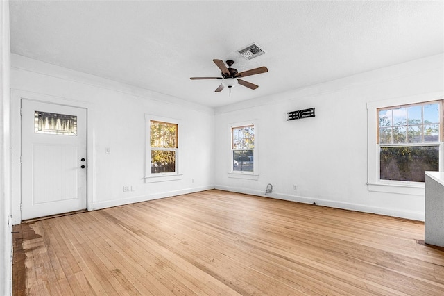 unfurnished room featuring visible vents, a ceiling fan, a textured ceiling, light wood finished floors, and baseboards