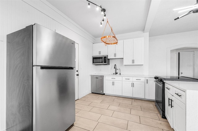 kitchen with a sink, white cabinetry, stainless steel appliances, a peninsula, and light countertops