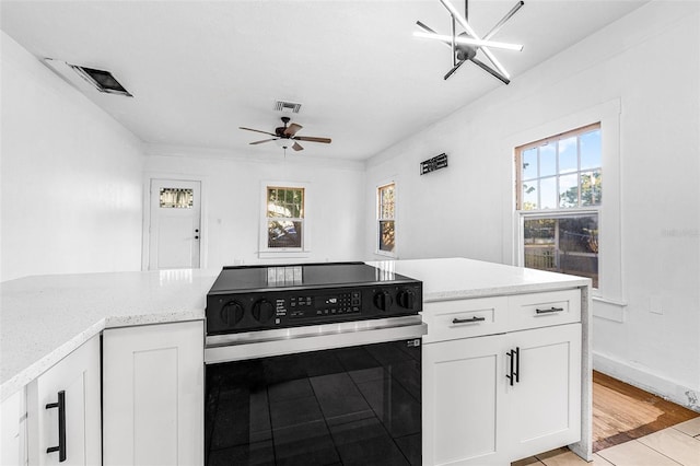 kitchen with visible vents, range with electric cooktop, a ceiling fan, and white cabinetry