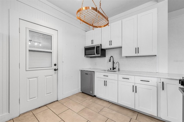 kitchen featuring a sink, appliances with stainless steel finishes, white cabinets, and light countertops