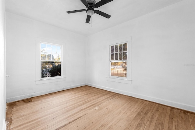 empty room featuring a ceiling fan, baseboards, and hardwood / wood-style flooring