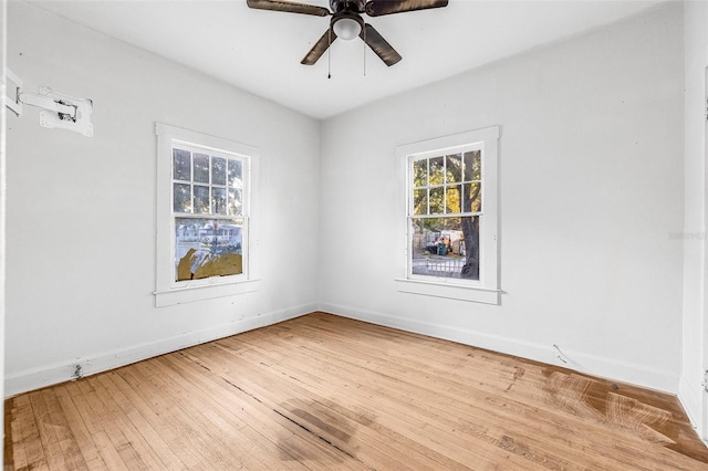 empty room with a ceiling fan, light wood-style floors, and baseboards