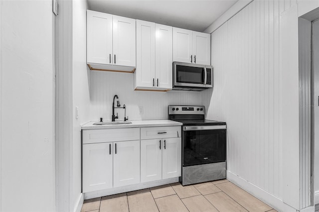 kitchen with white cabinetry, light countertops, appliances with stainless steel finishes, and a sink