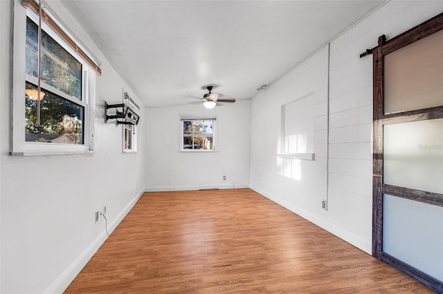 spare room with baseboards, ceiling fan, and wood finished floors