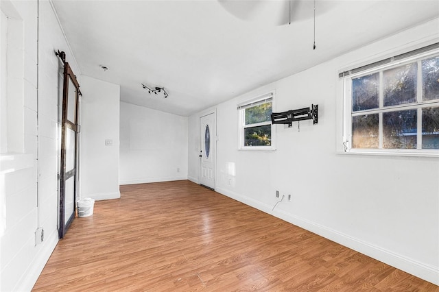 unfurnished living room with light wood-style flooring, baseboards, and ceiling fan