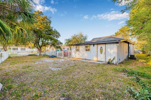 back of house featuring central AC and fence