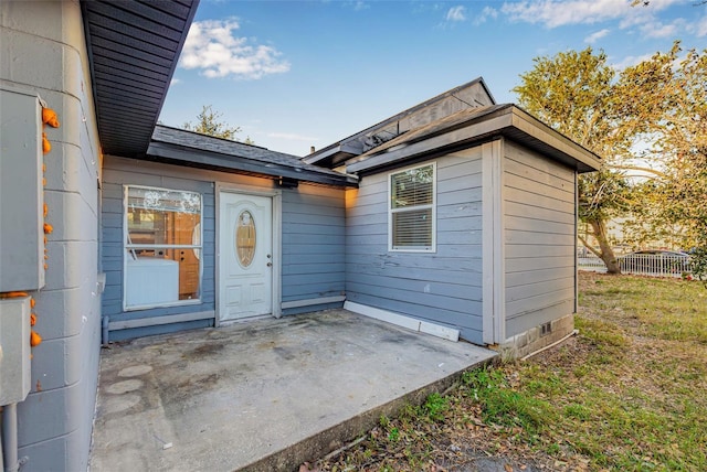 entrance to property featuring a patio area and fence