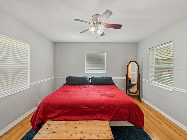 bedroom with wood finished floors, baseboards, and ceiling fan