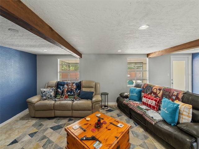 living room featuring beamed ceiling, a textured wall, baseboards, and a textured ceiling