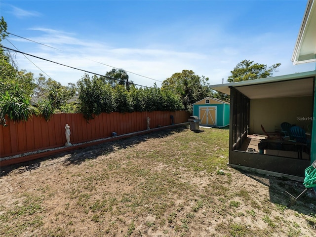 view of yard featuring a storage shed, an outdoor structure, and fence