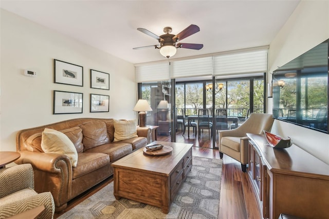 living room featuring dark wood-style floors and a ceiling fan