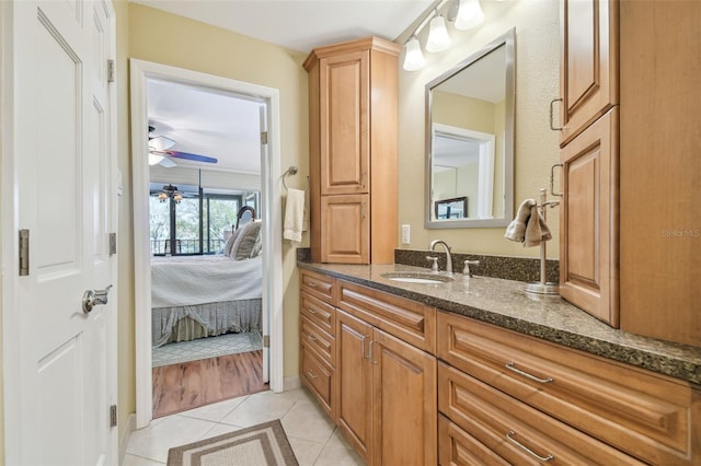 ensuite bathroom with tile patterned flooring, connected bathroom, vanity, and a ceiling fan