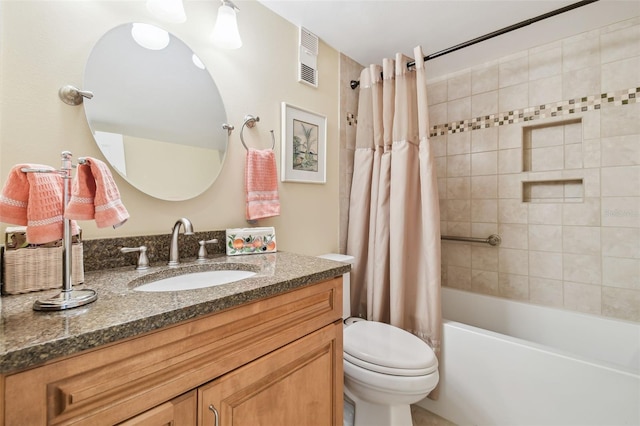 bathroom with visible vents, vanity, toilet, and shower / bath combo with shower curtain