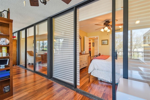 bedroom featuring a textured ceiling, wood finished floors, and expansive windows