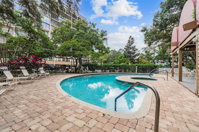 view of pool featuring a patio area, a hot tub, and fence