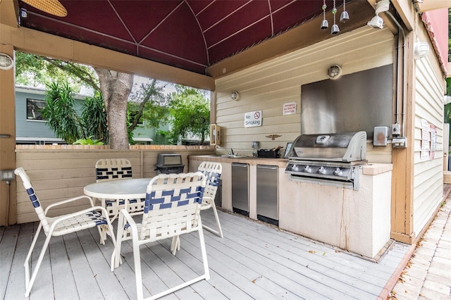 wooden terrace with a gazebo, grilling area, exterior kitchen, and outdoor dining area