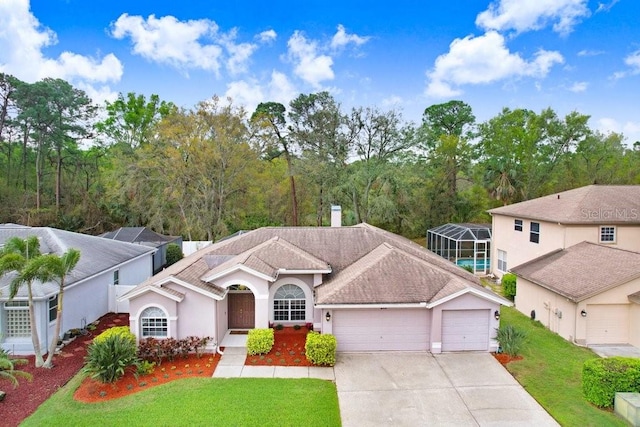 view of front of home featuring concrete driveway, an attached garage, a front yard, and a chimney