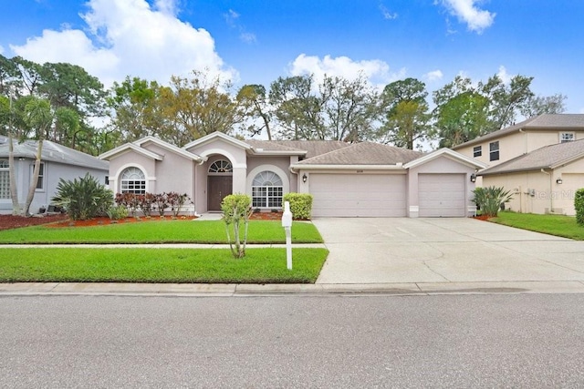 ranch-style home featuring a front lawn, an attached garage, concrete driveway, and stucco siding