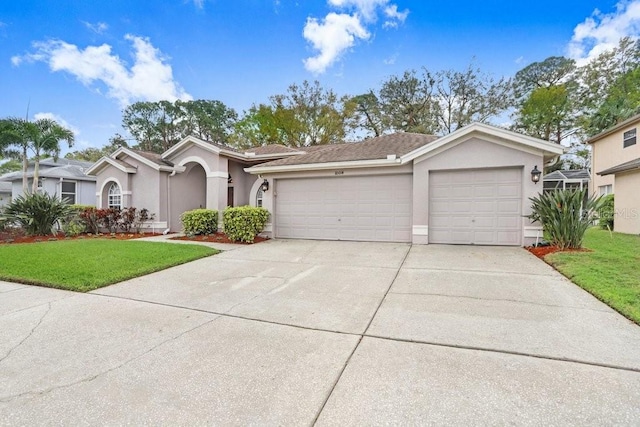 single story home with stucco siding, a garage, concrete driveway, and a front lawn