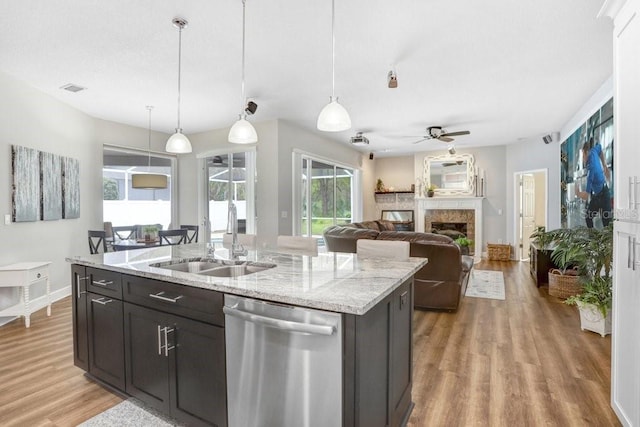 kitchen with light wood finished floors, visible vents, ceiling fan, dishwasher, and a sink