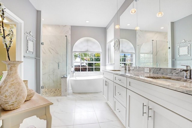 bathroom featuring a soaking tub, marble finish floor, a marble finish shower, and a sink