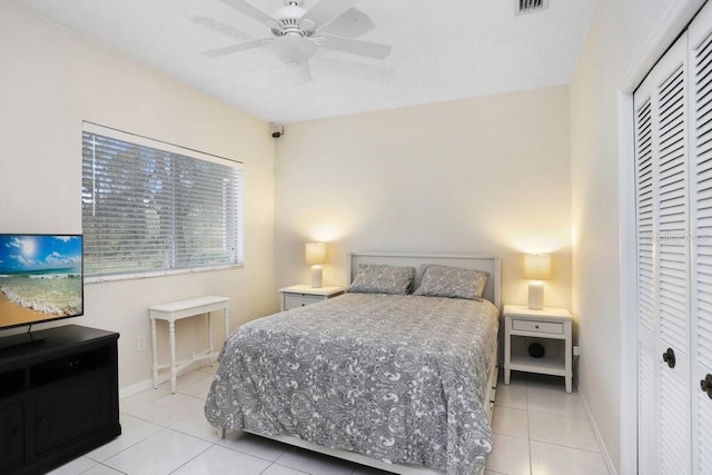 bedroom featuring light tile patterned floors, a closet, baseboards, and visible vents