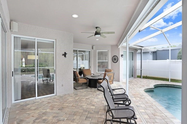 view of swimming pool with a ceiling fan, a fenced in pool, fence, a lanai, and a patio area